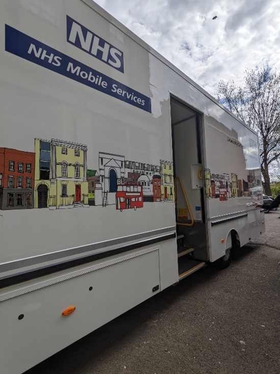 Side of Find & Treat mobile health unit with illustration of houses and NHS logo