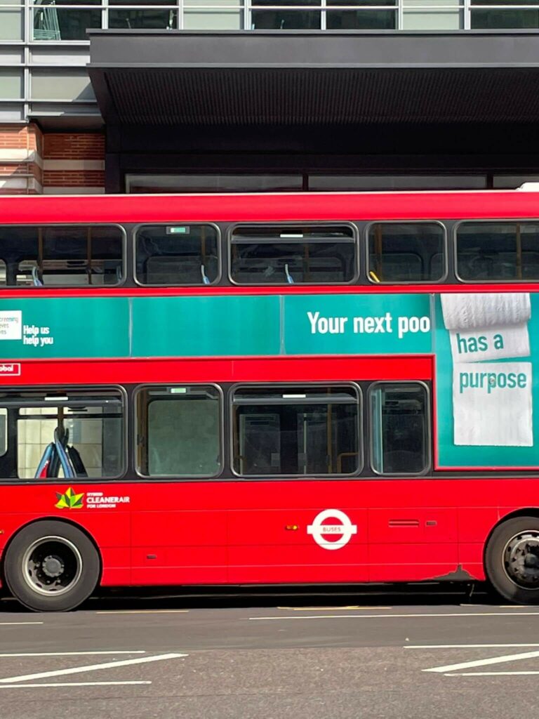 Photo of a bus in London with the campaign graphic - your next poo has a purpose